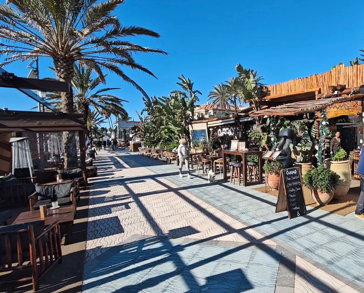 The palm-lined promenade with chiringuito terraces